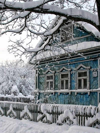 Traditional Russian hut (izba) with carved wooden details and flower garden