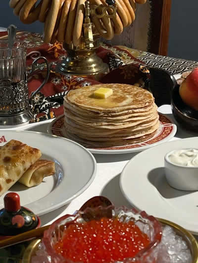 Close-up of Russian cuisine: blini with jam, samovar and sweet pastries
